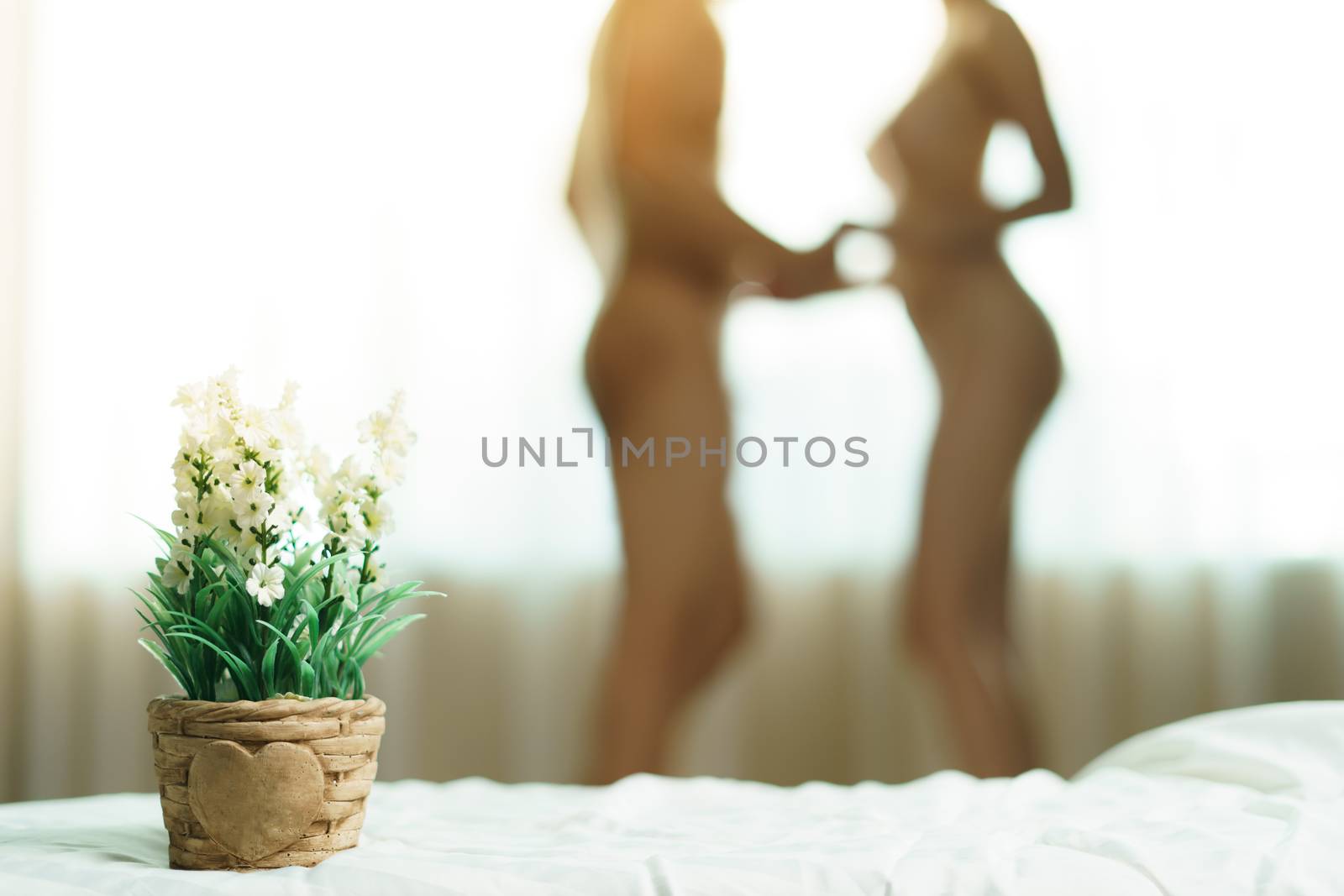 Blurred naked couple standing together at window and holds her h by sirawit99