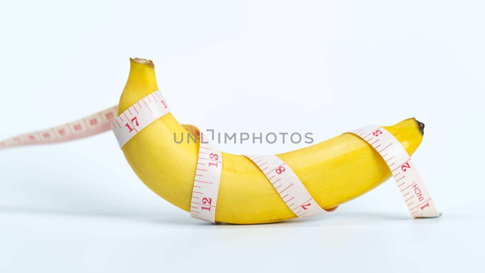 A banana was wrapped in a measuring tape. by sirawit99