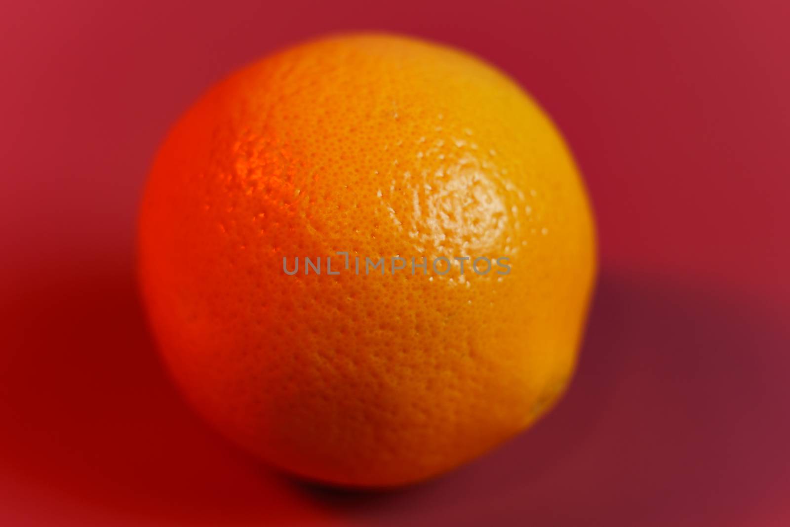 Orange fruit with red background.