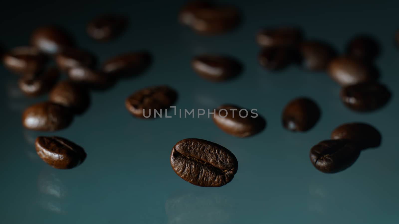 Roasted coffee beans pile on glass reflection background.