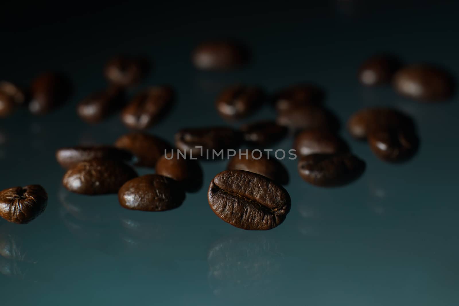 Roasted coffee beans pile on glass reflection background.