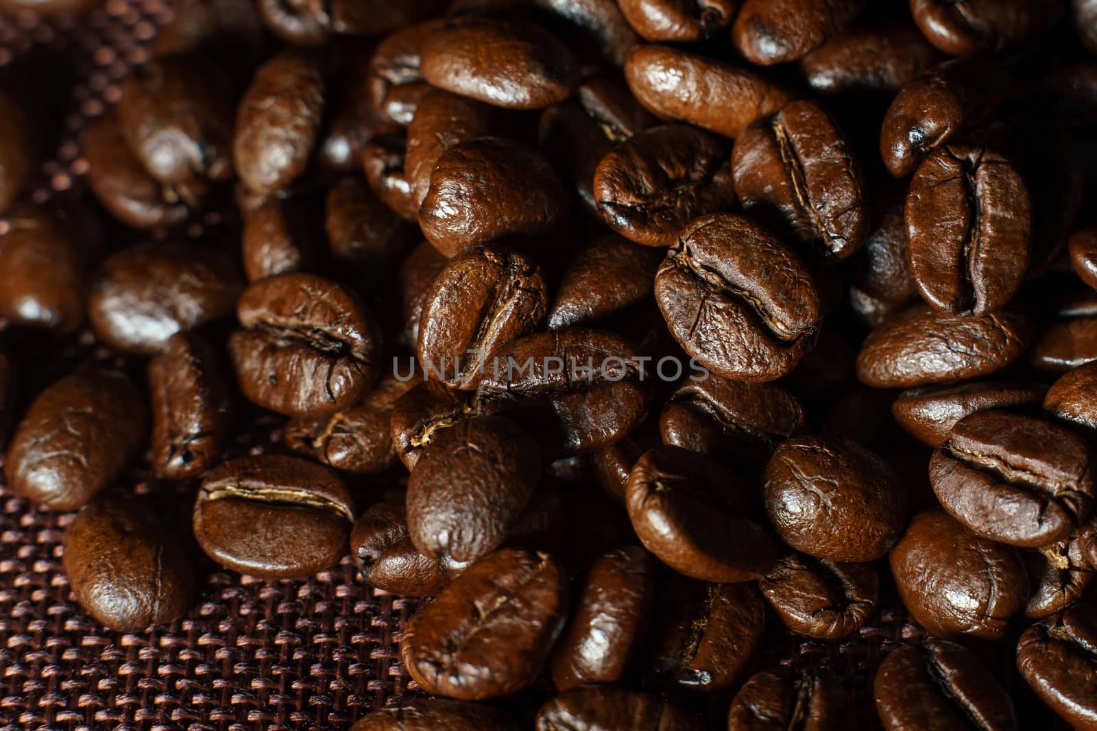 Roasted coffee beans pile on burlap