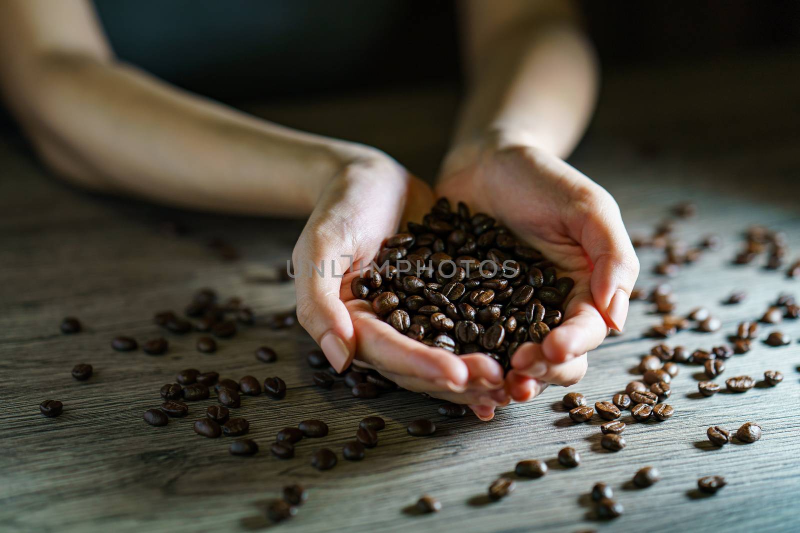 Woman's hands holding roasted coffee beans, closeup by sirawit99