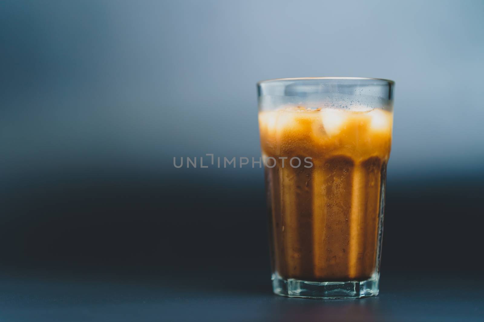 Ice coffee in a tall glass on dark background. by sirawit99