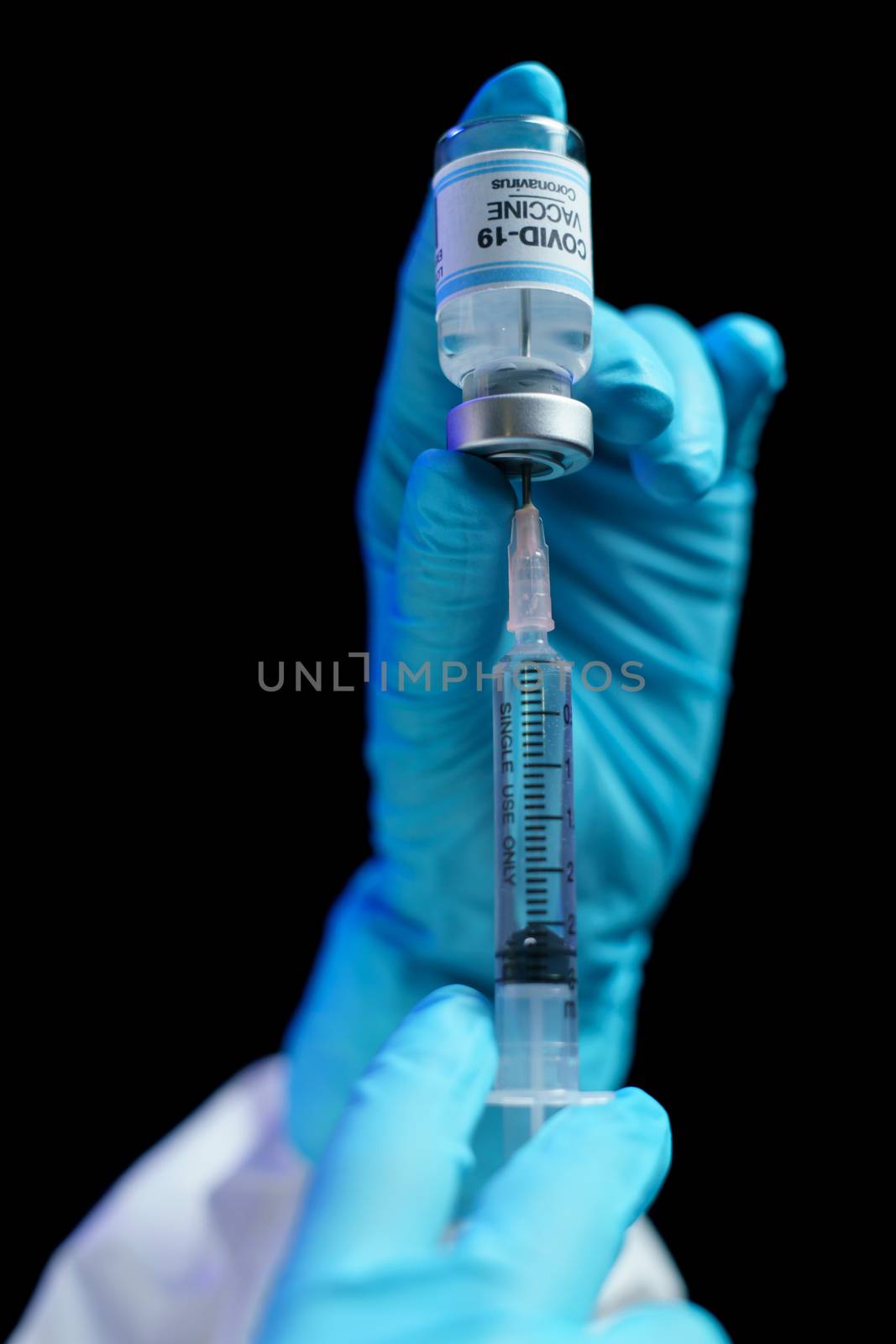 Hand in blue glove holding vaccine and syringe injection for prevention, immunization and treatment from corona virus infection.