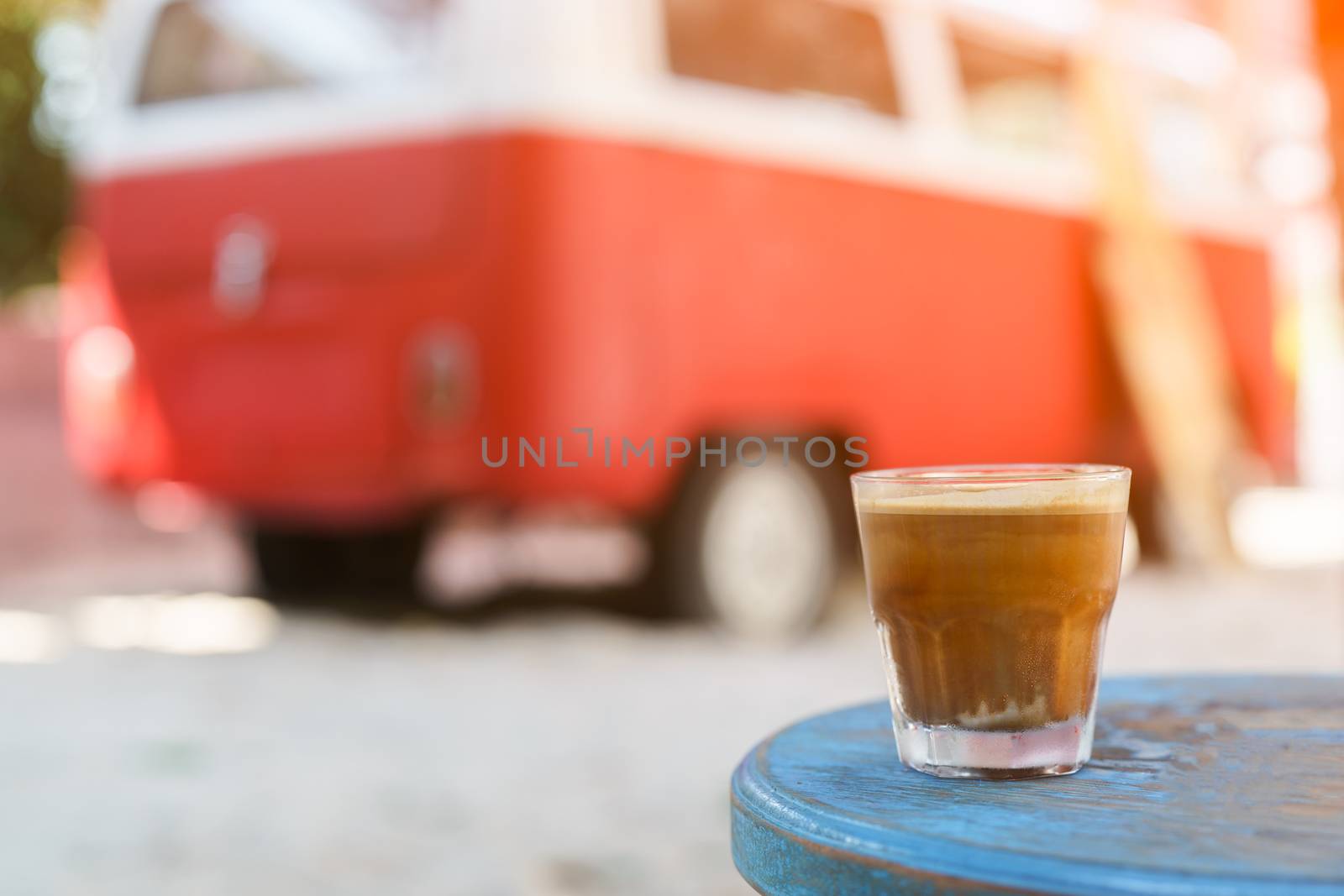 Dirty Coffee : glass of espresso shot mixed with cold fresh milk on blurred beach background.