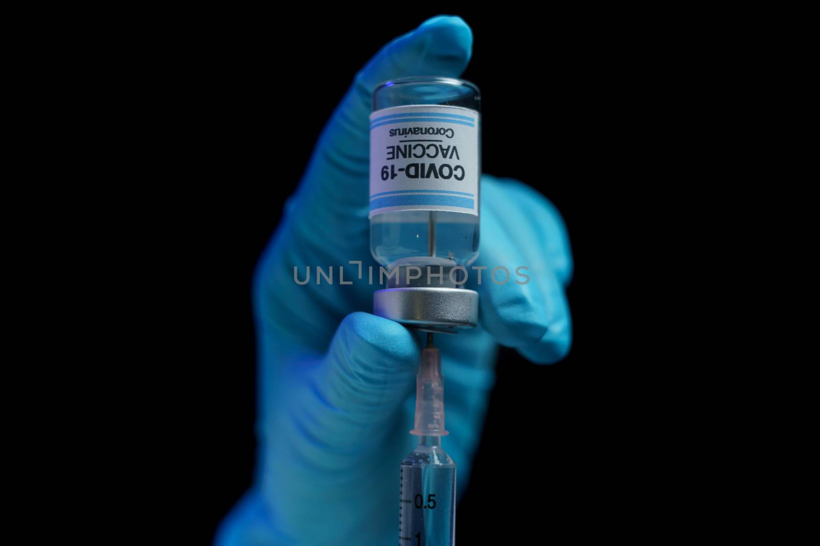 Hand in blue glove holding vaccine and syringe injection for prevention, immunization and treatment from corona virus infection.