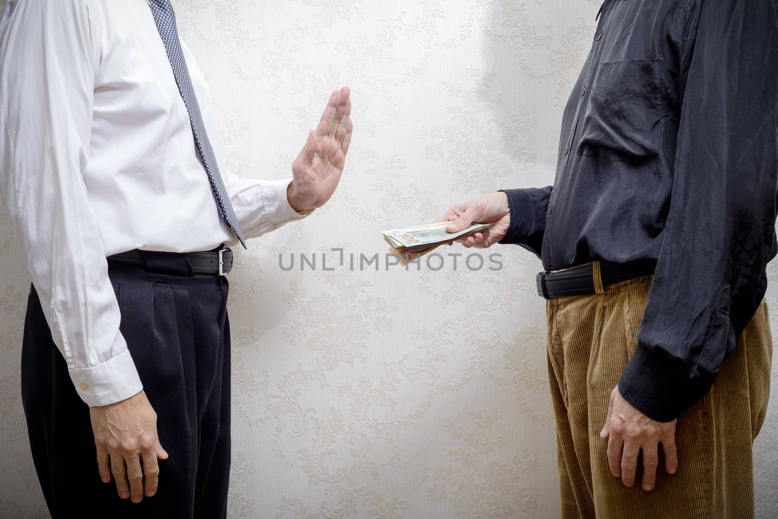 Corrupted man offering a Dollars banknotes bribe to a businessman, or politician, rejecting any kind of corruption