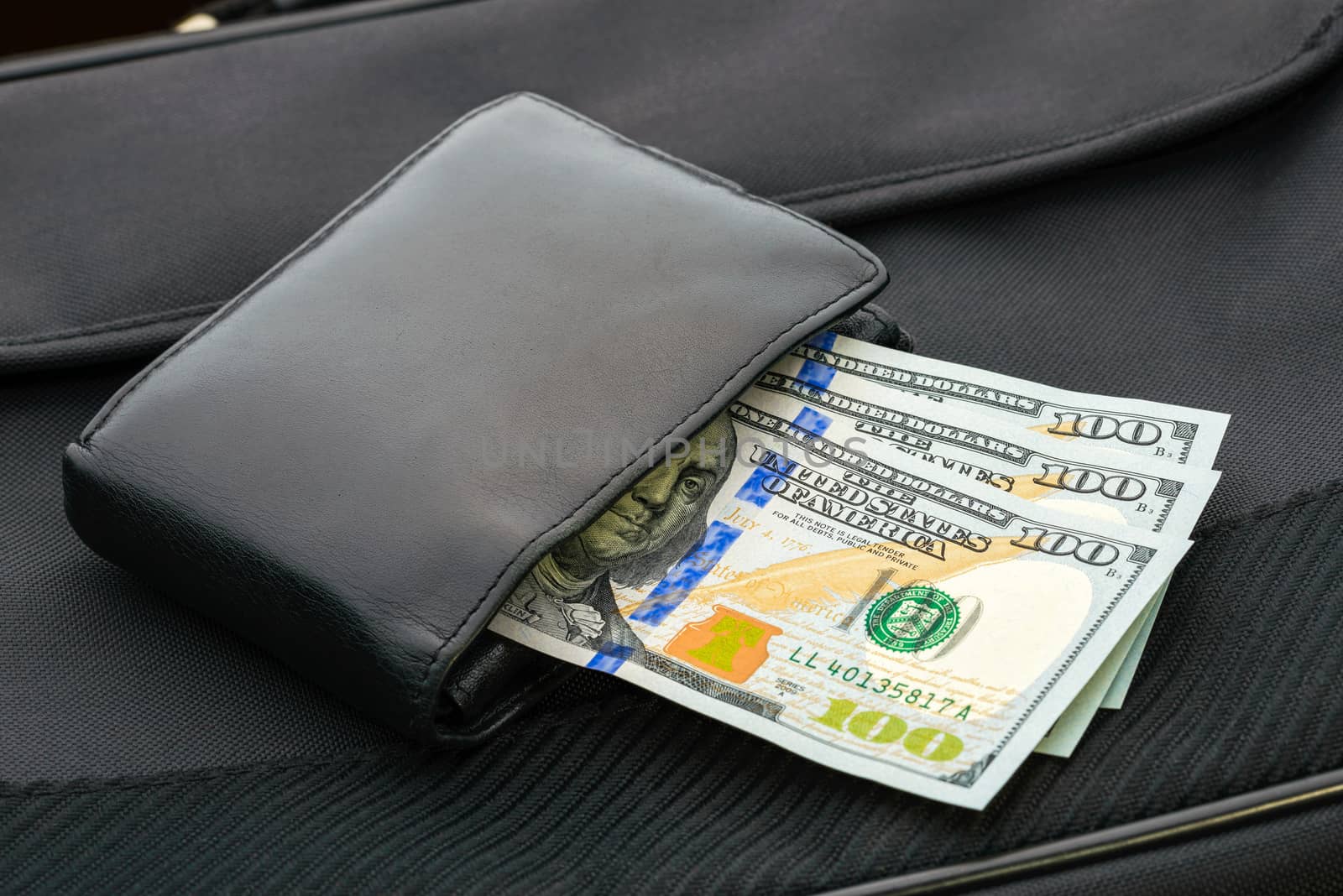 A black leather wallet with Dollar banknotes
