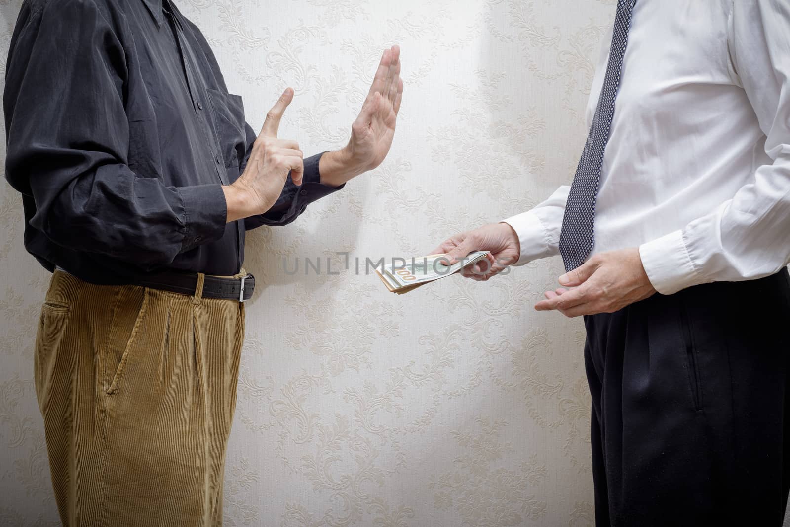 Corrupted businessman, or politician, offering a Dollars banknotes bribe to a man rejecting any kind of corruption