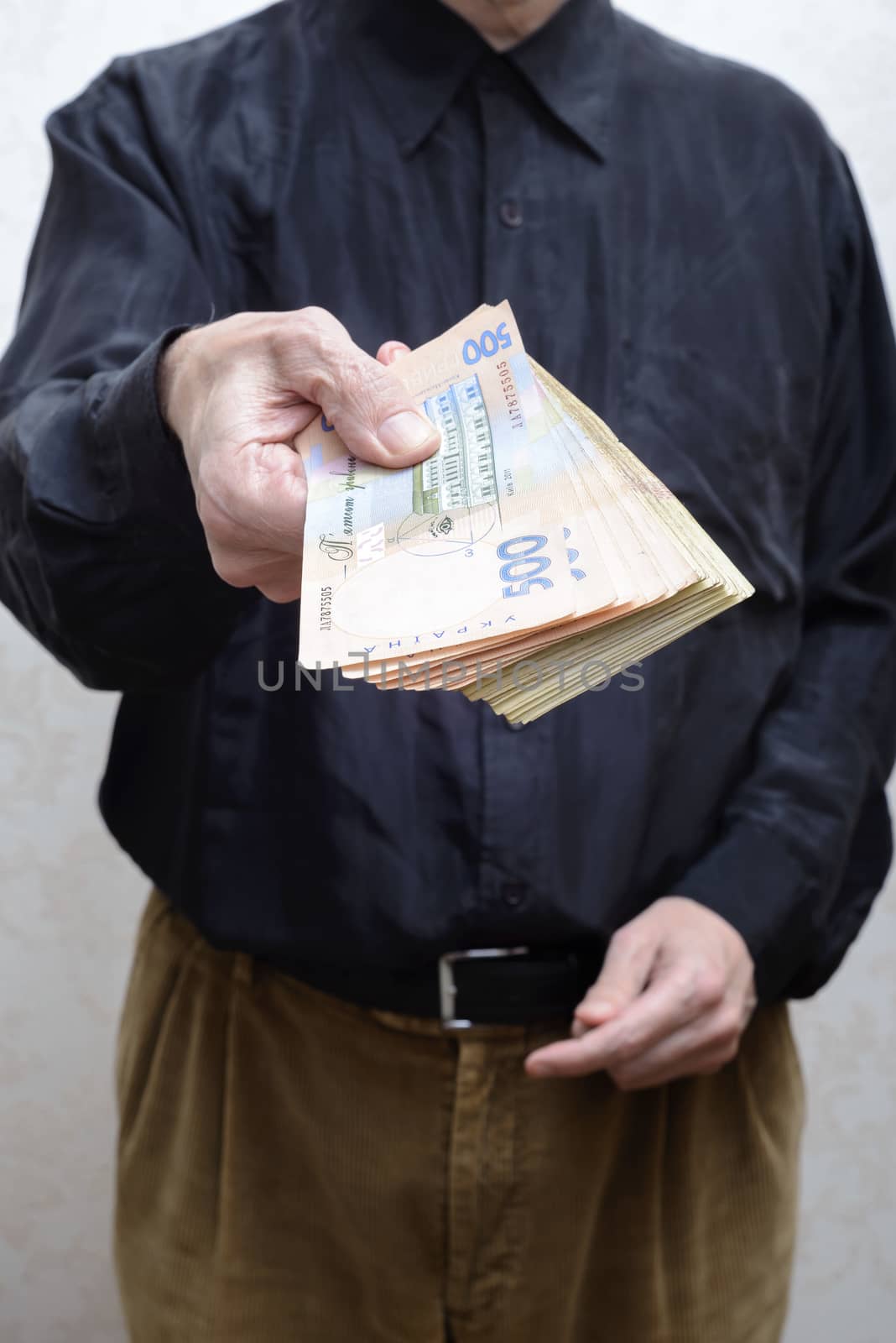 Corrupted businessman, or politician, offering a Hryvnia banknotes bribe, in Ukraine