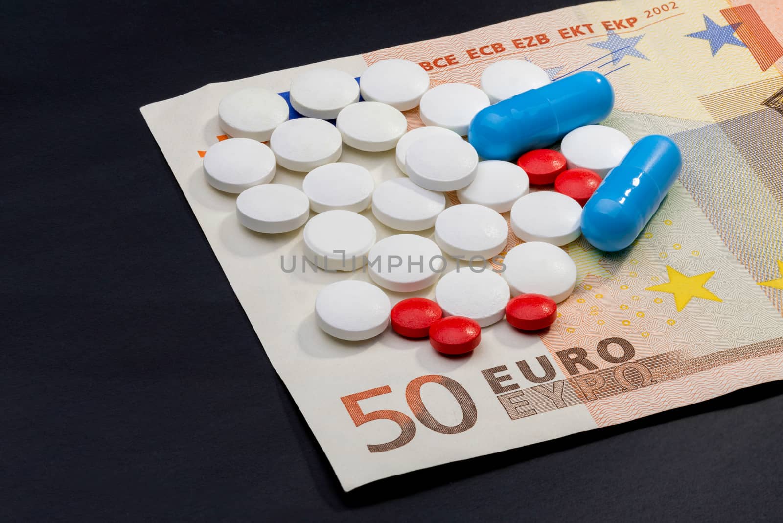 Pils and capsules with a fifty Euro banknote