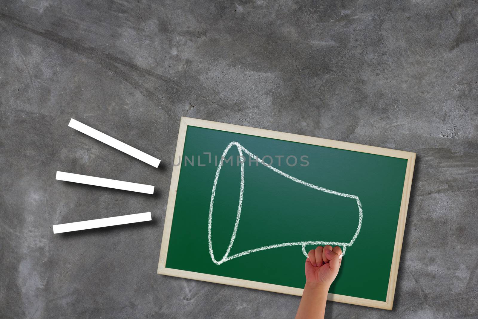 Communication and announcement concept, hand holding megaphone on concrete background