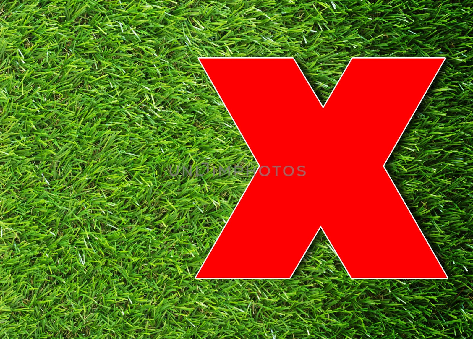 Red cross on green grass background, wrong concept
