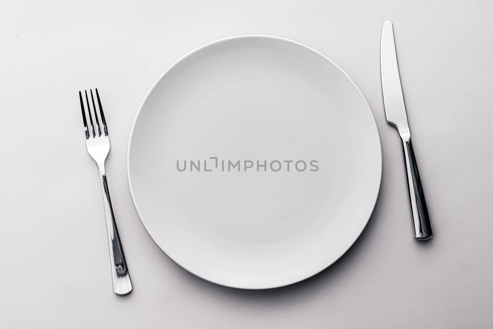 Empty plate and cutlery as mockup set on white background, top tableware for chef table decor and menu branding by Anneleven