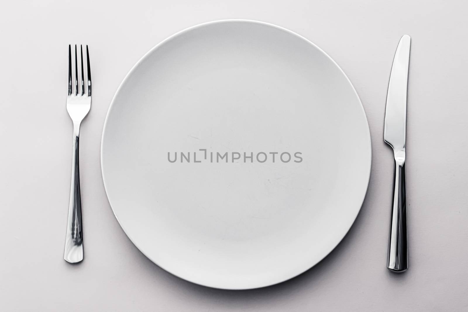 Empty plate and cutlery as mockup set on white background, top tableware for chef table decor and menu branding design