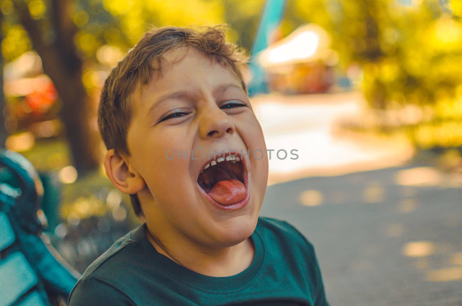 close portrait of a laughing young boy in the forest