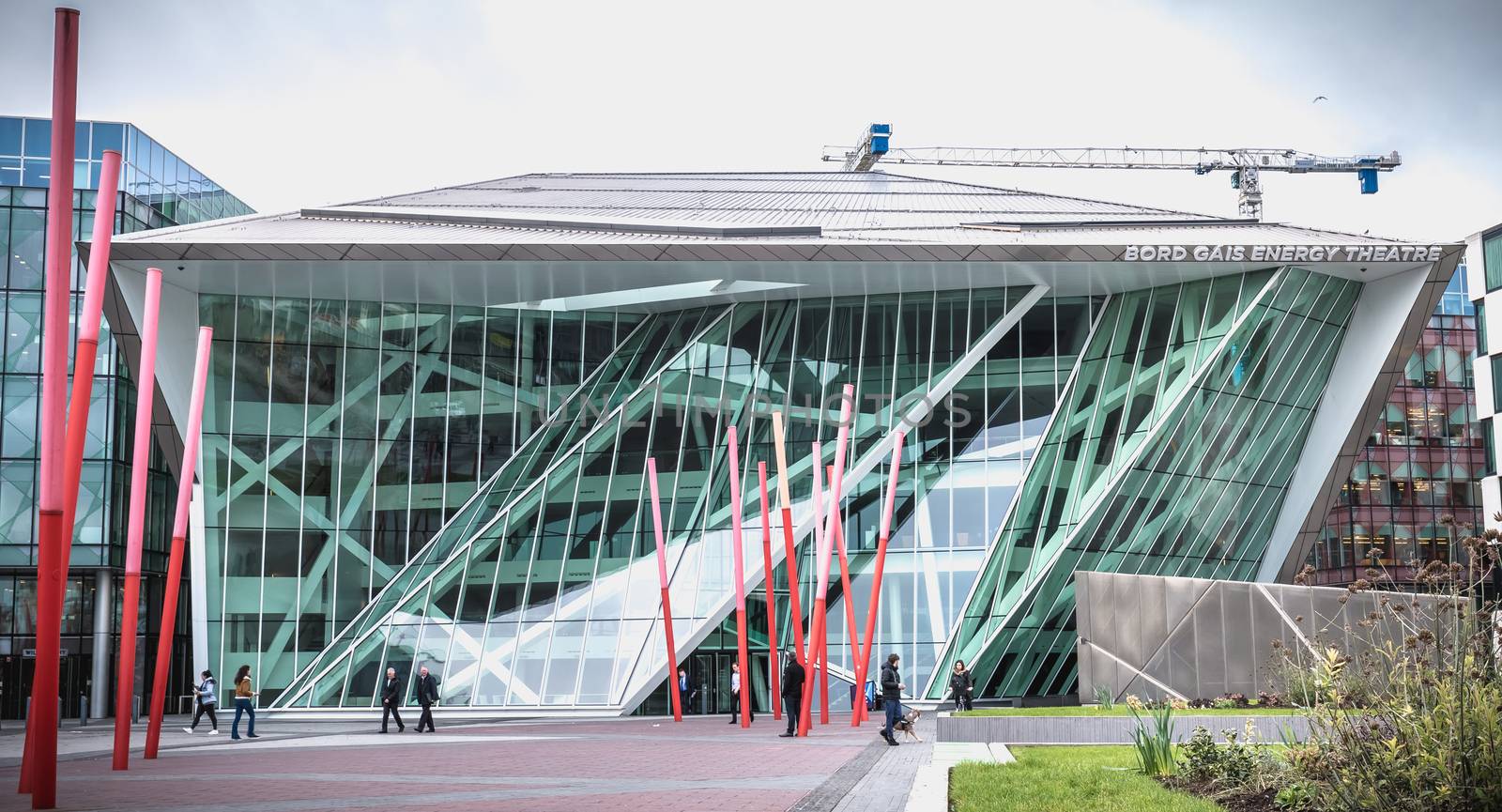 Dublin, Ireland - February 12, 2019: People walking in front of the Gais Energy Theater in the Docks area on a winter day