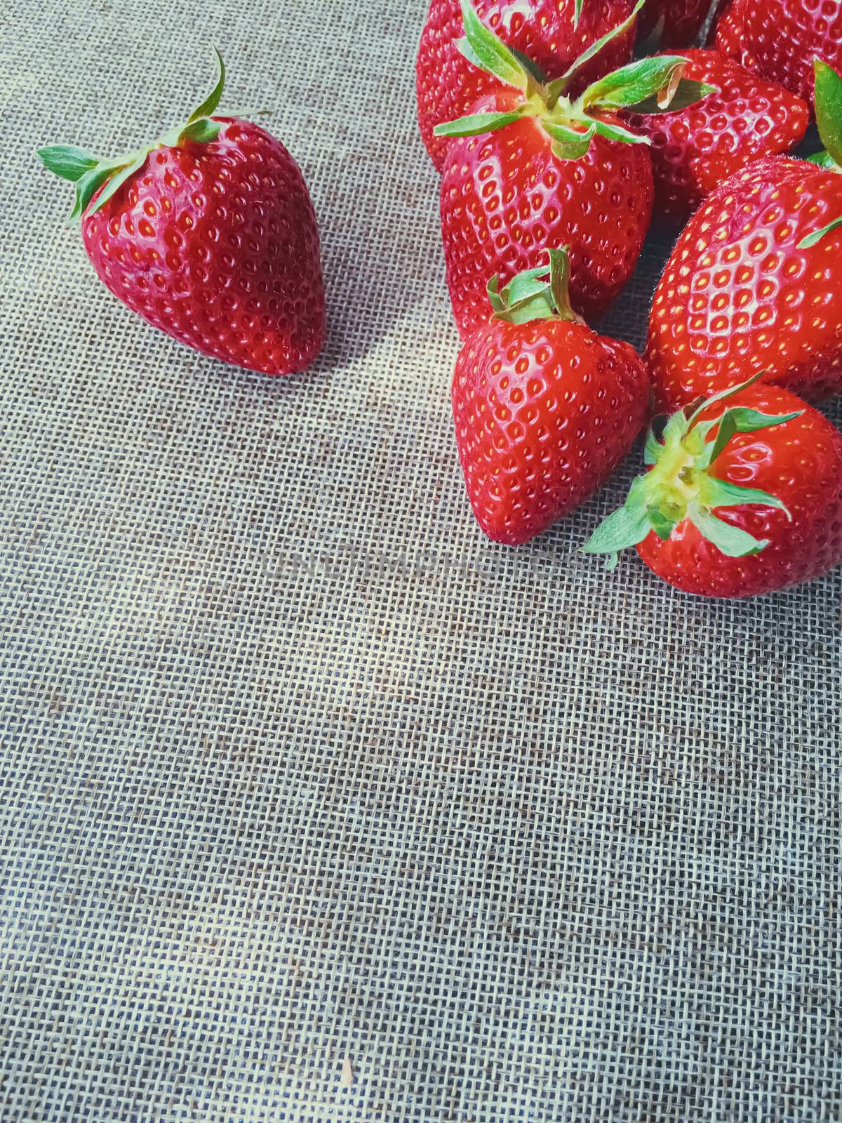 Organic strawberries on rustic linen background by Anneleven