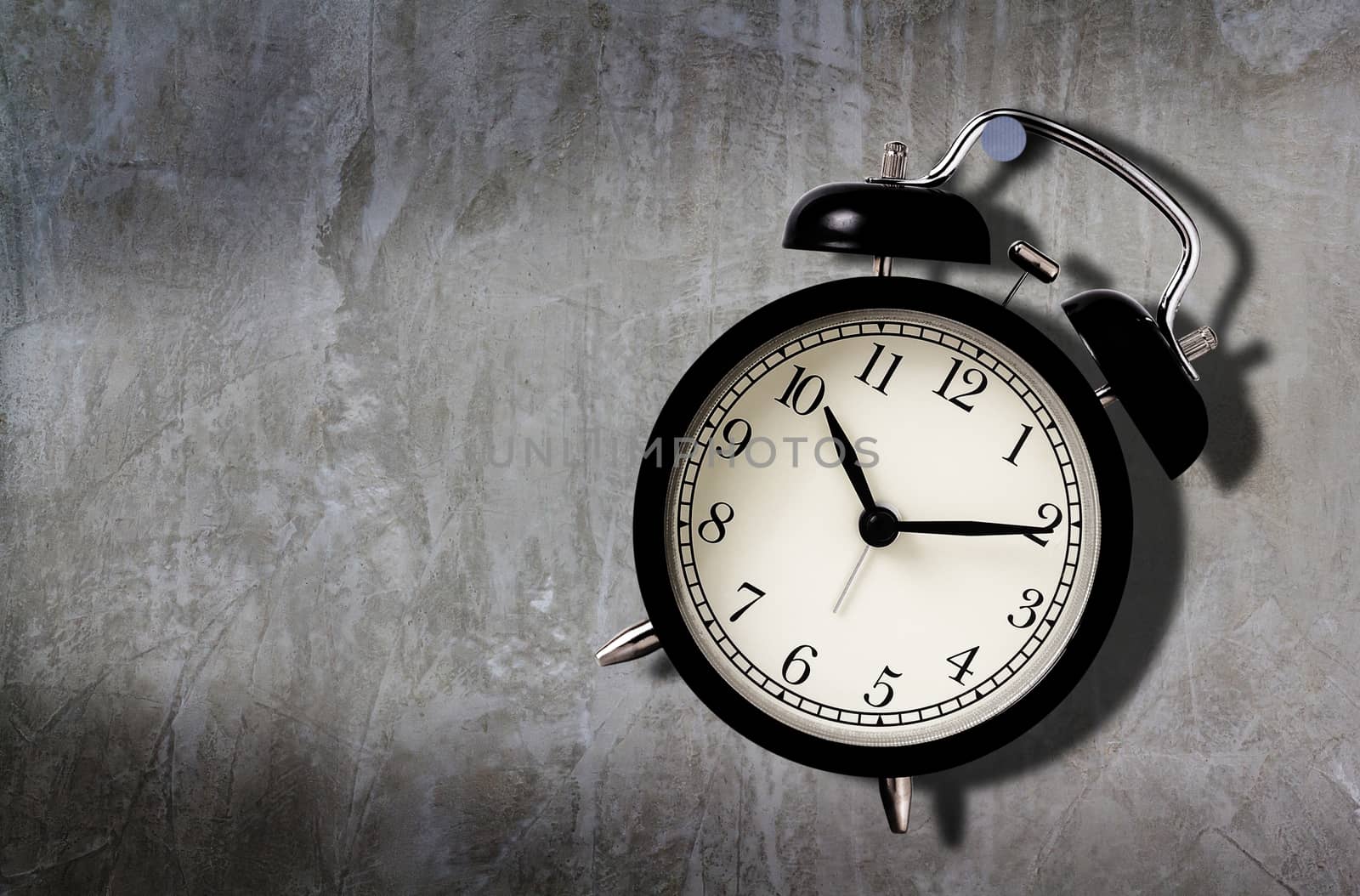 Time management concept, business planning, patience under pressure, alarm clock hang on the concrete wall 