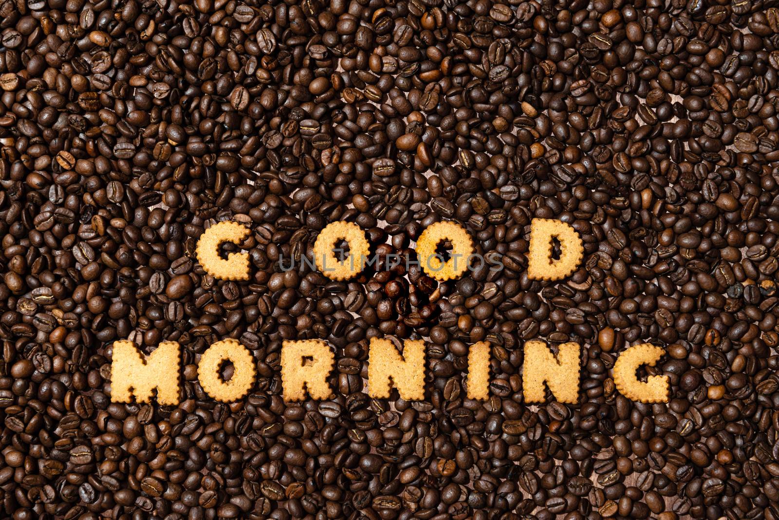 The words GOOD MORNING made from biscuit letters on a dark coffee bean background - image