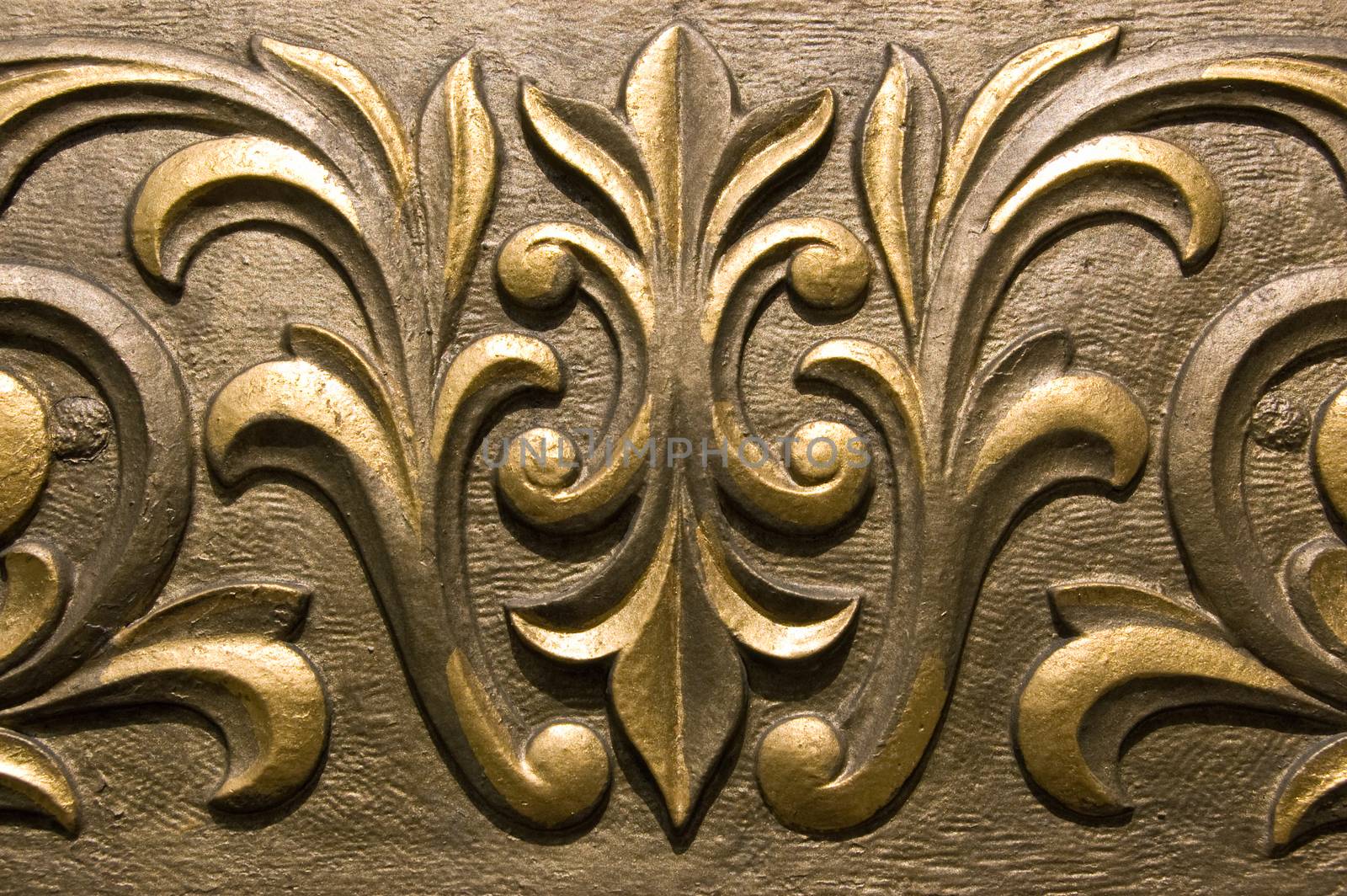 Ornate moulded plaster painted in a golden paint. Outside decoration of a Victorian public House in London.