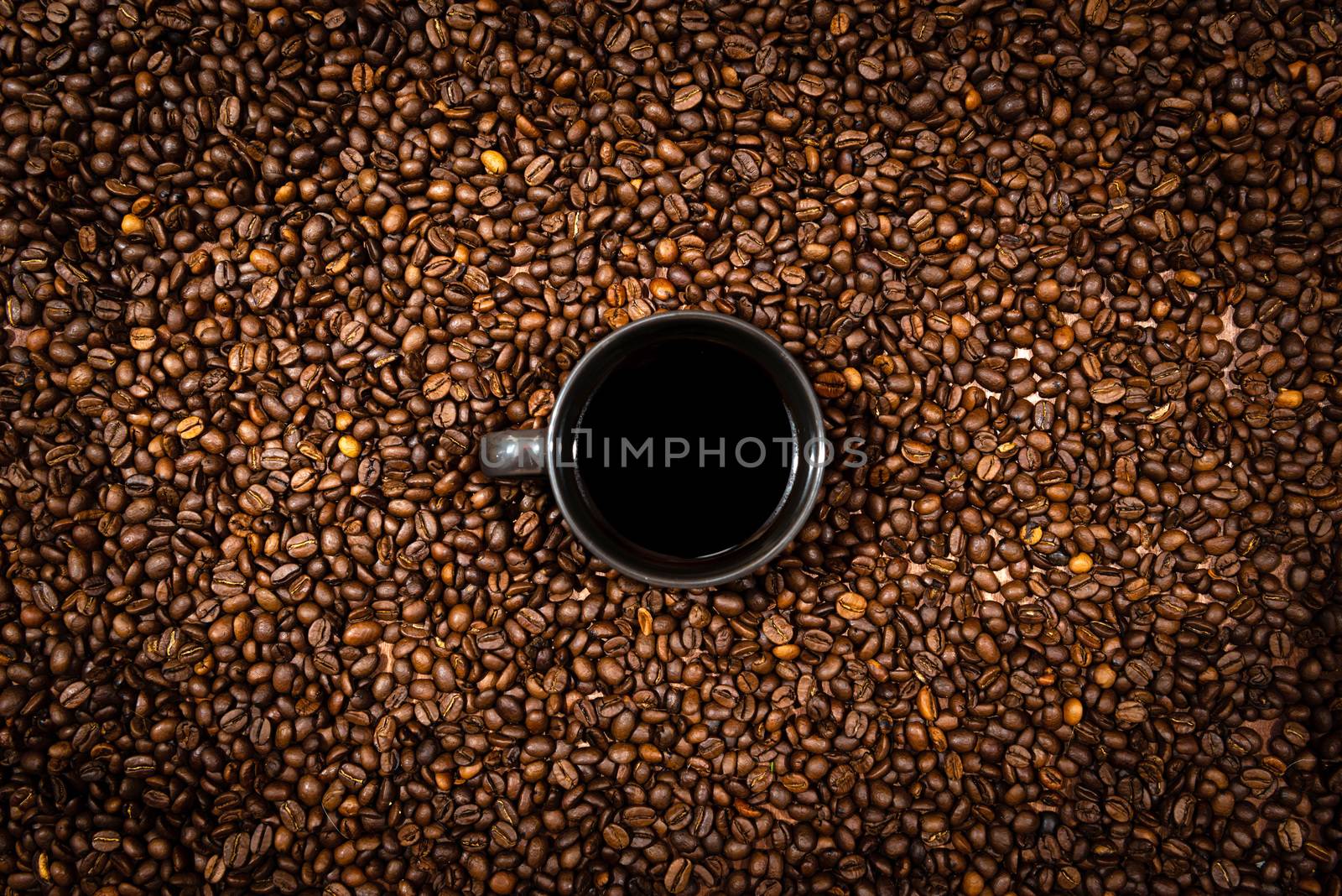 Top view of black coffee mug on the coffee beans background - image