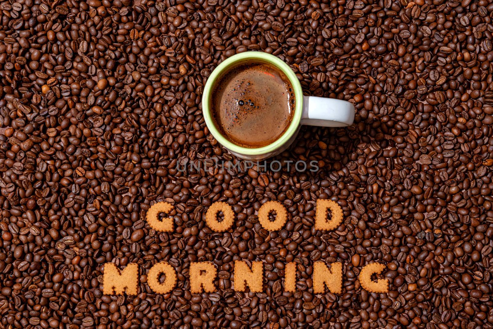 White caffee mug and words GOOD MORNING made from biscuit letters on a dark coffee bean background - image