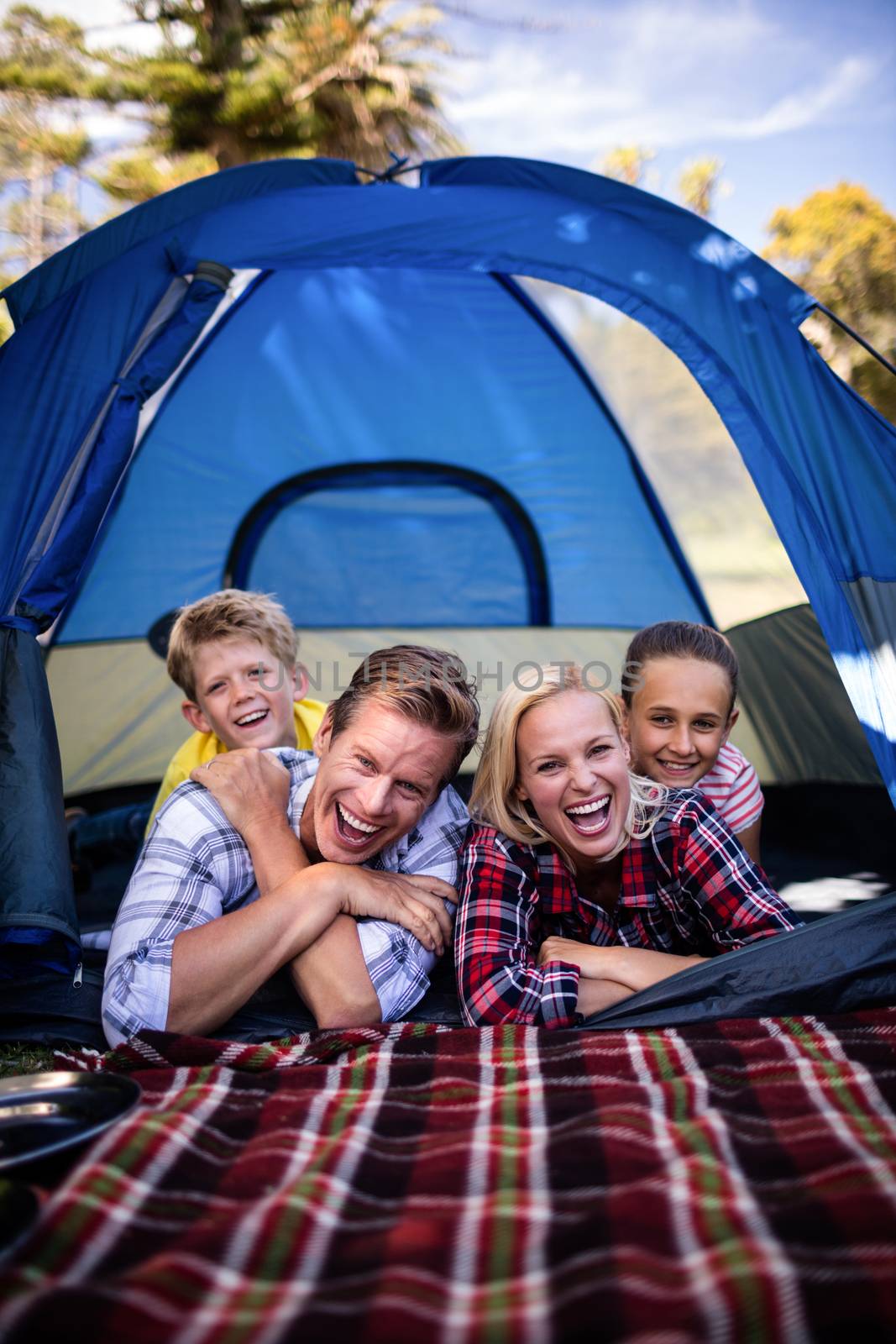 Happy family lying in a tent by Wavebreakmedia