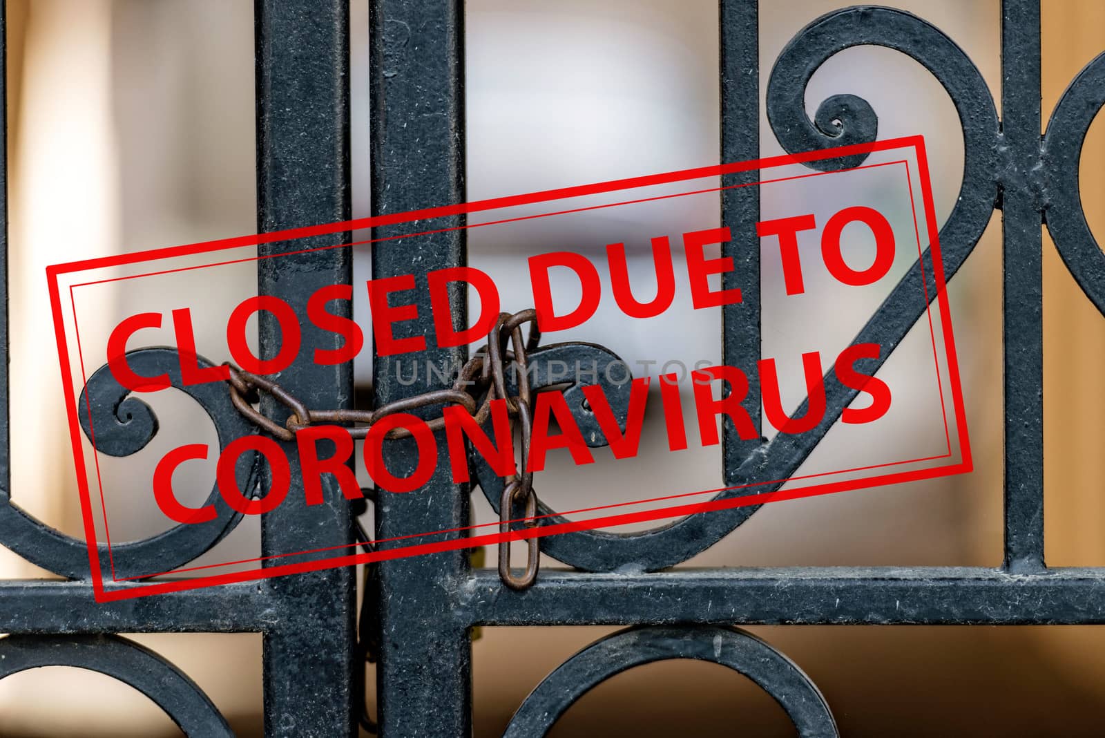 Closed Due To Coronavirus - sign on the background of an ornamental iron gate locked with chain