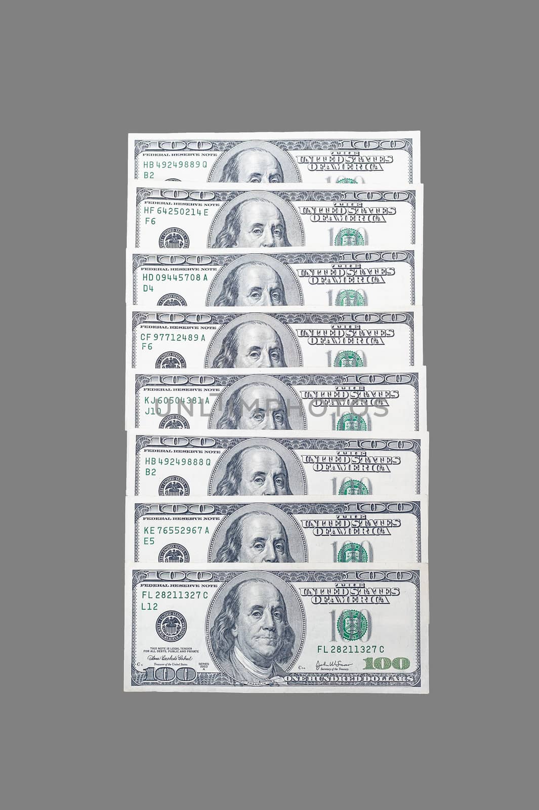 stacked in a row 100 US dollar bills with a portrait of American President Benjamin Franklin on an isolated gray background