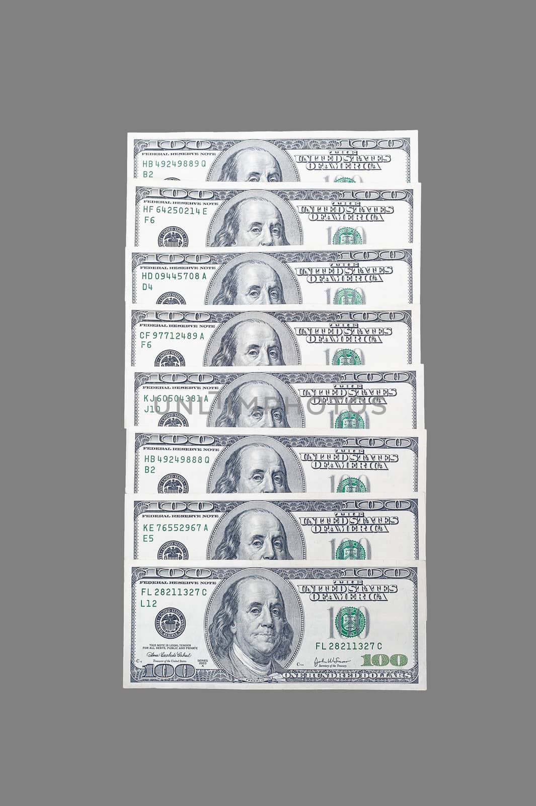 stacked in a row 100 US dollar bills with a portrait of American President Benjamin Franklin on an isolated gray background