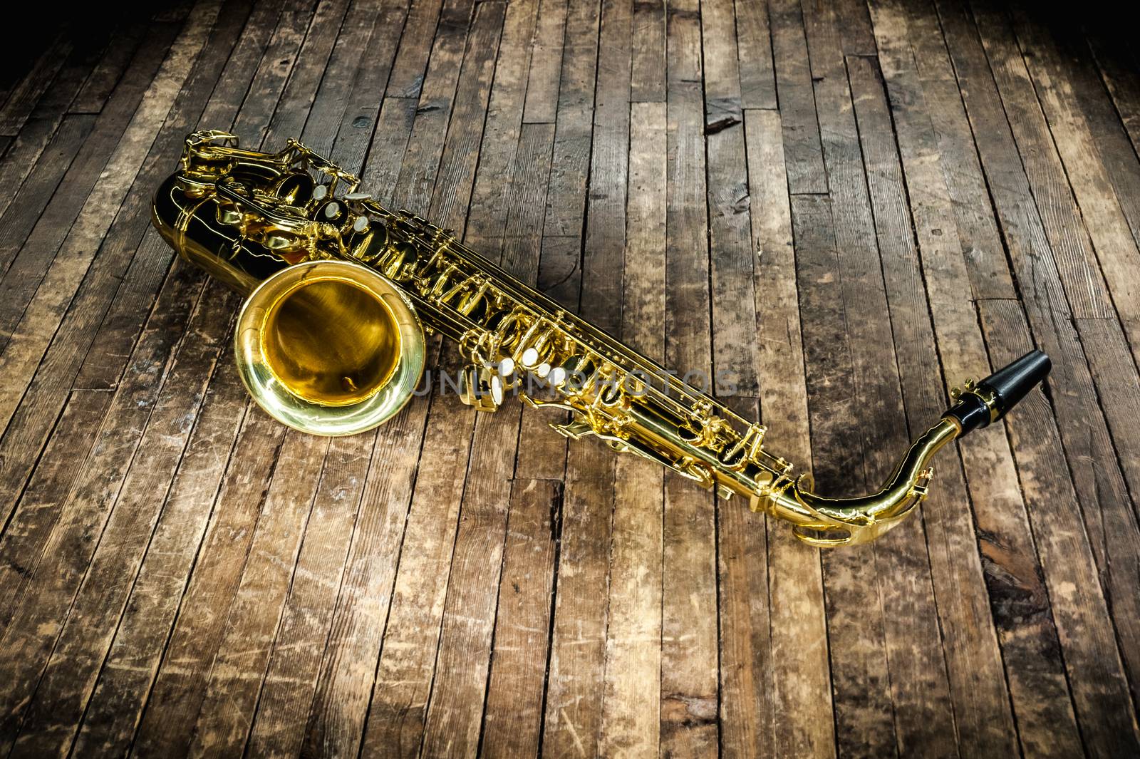 golden saxophone wind instrument on wooden brown stage