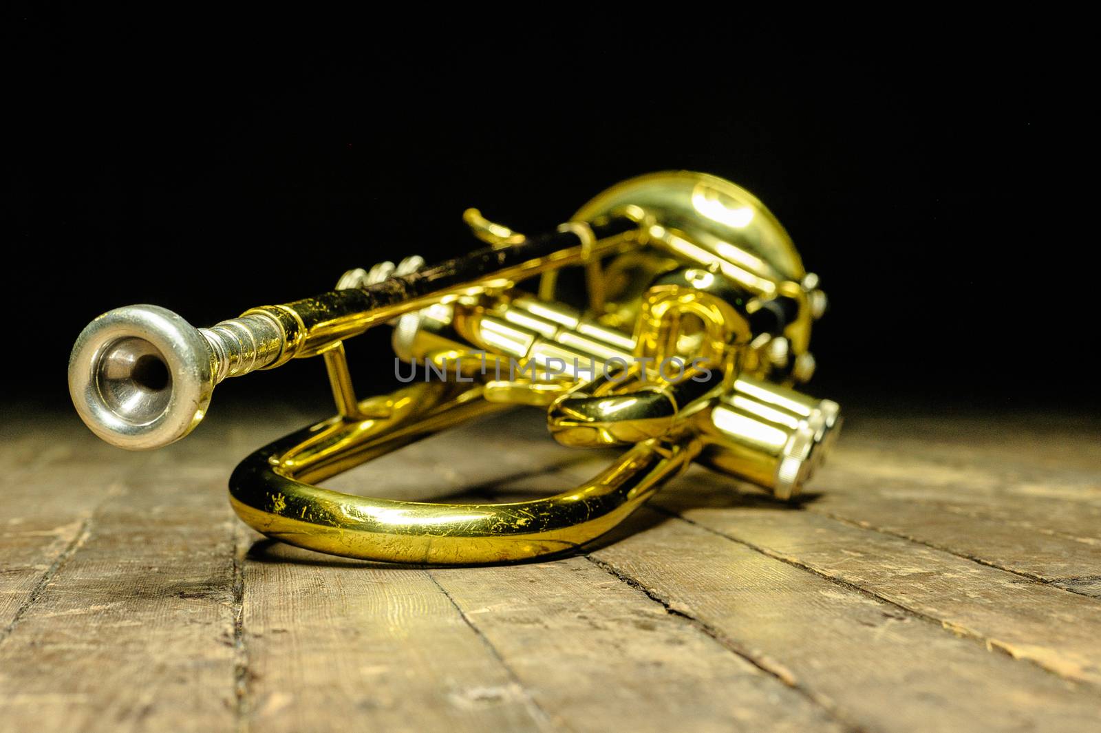 Brass instrument - yellow trumpet on stage with backlight