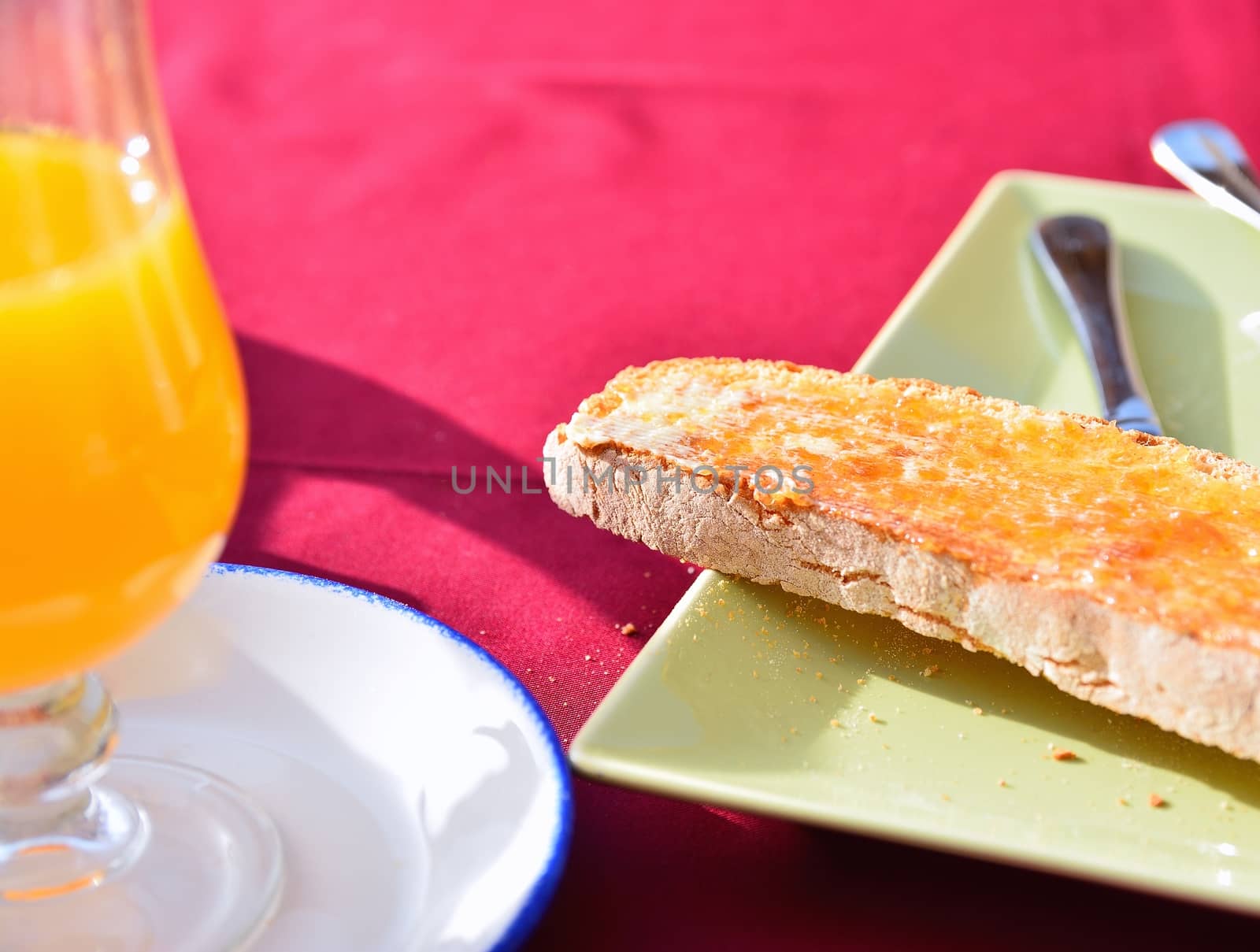Orange juice and toast with butter and jam for breakfast.