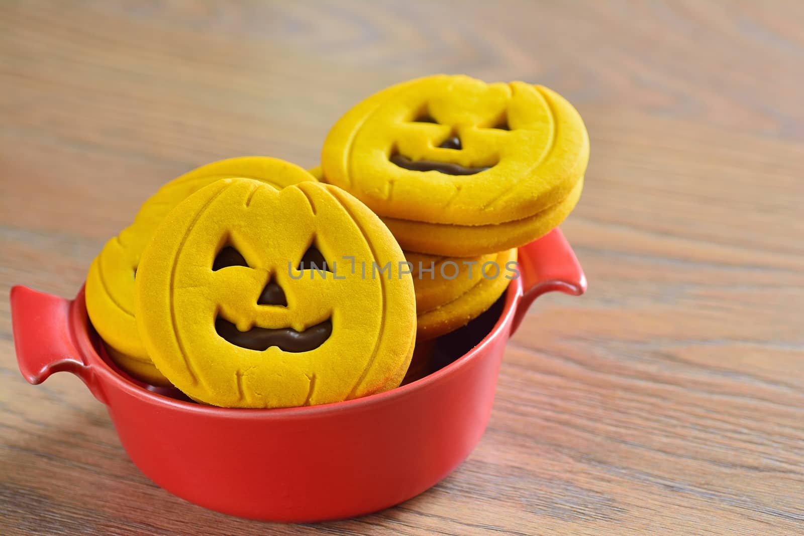 Halloween cookies with pumpkin shape on the kitchen table