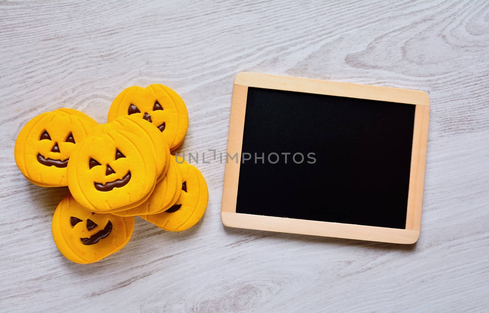 Halloween cookies with pumpkin shape on the kitchen table