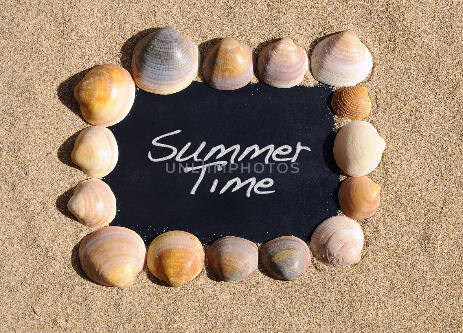 Blackboard on beach sand with the phrase summer time.