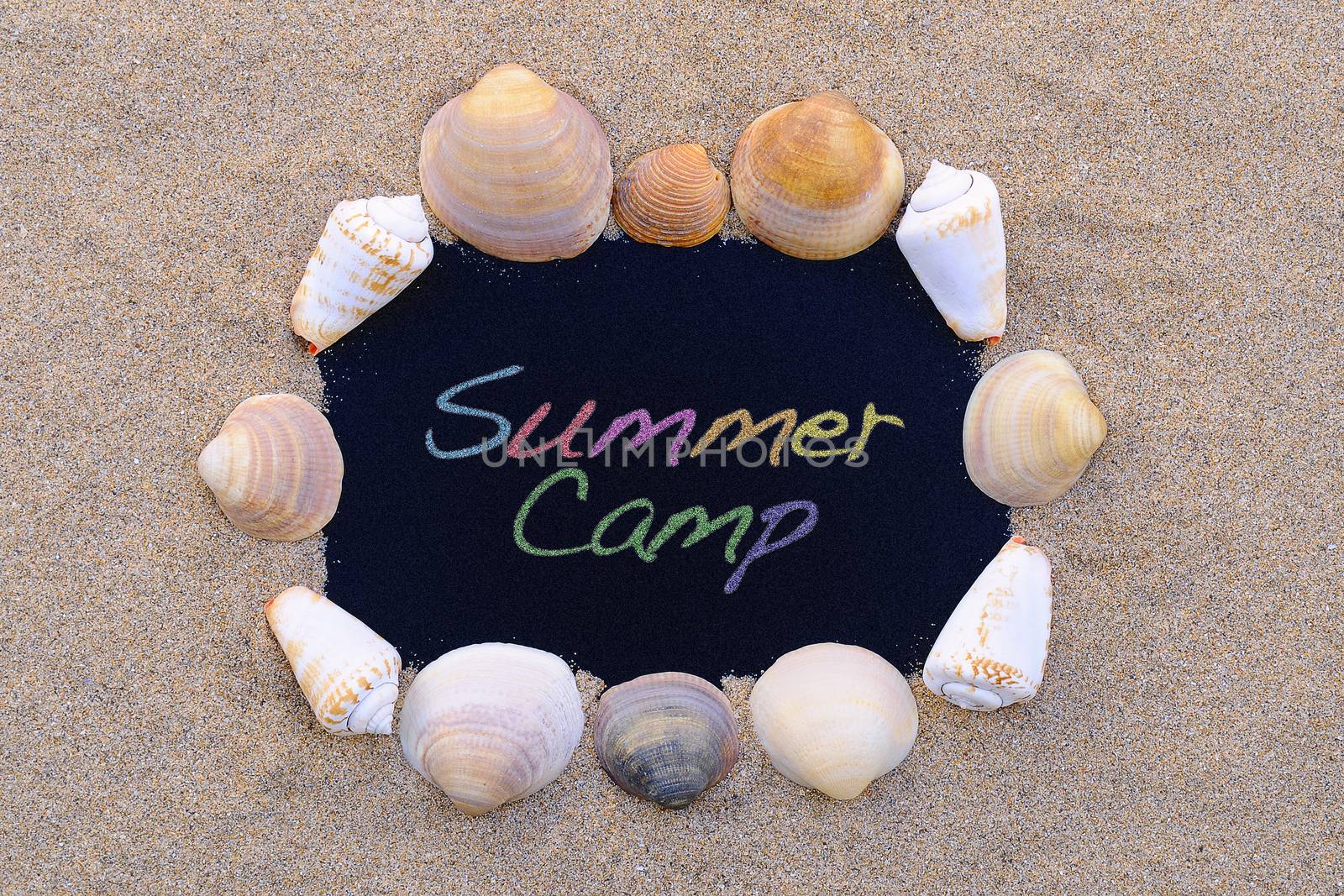Blackboard on the beach with the phrase Summer camp.