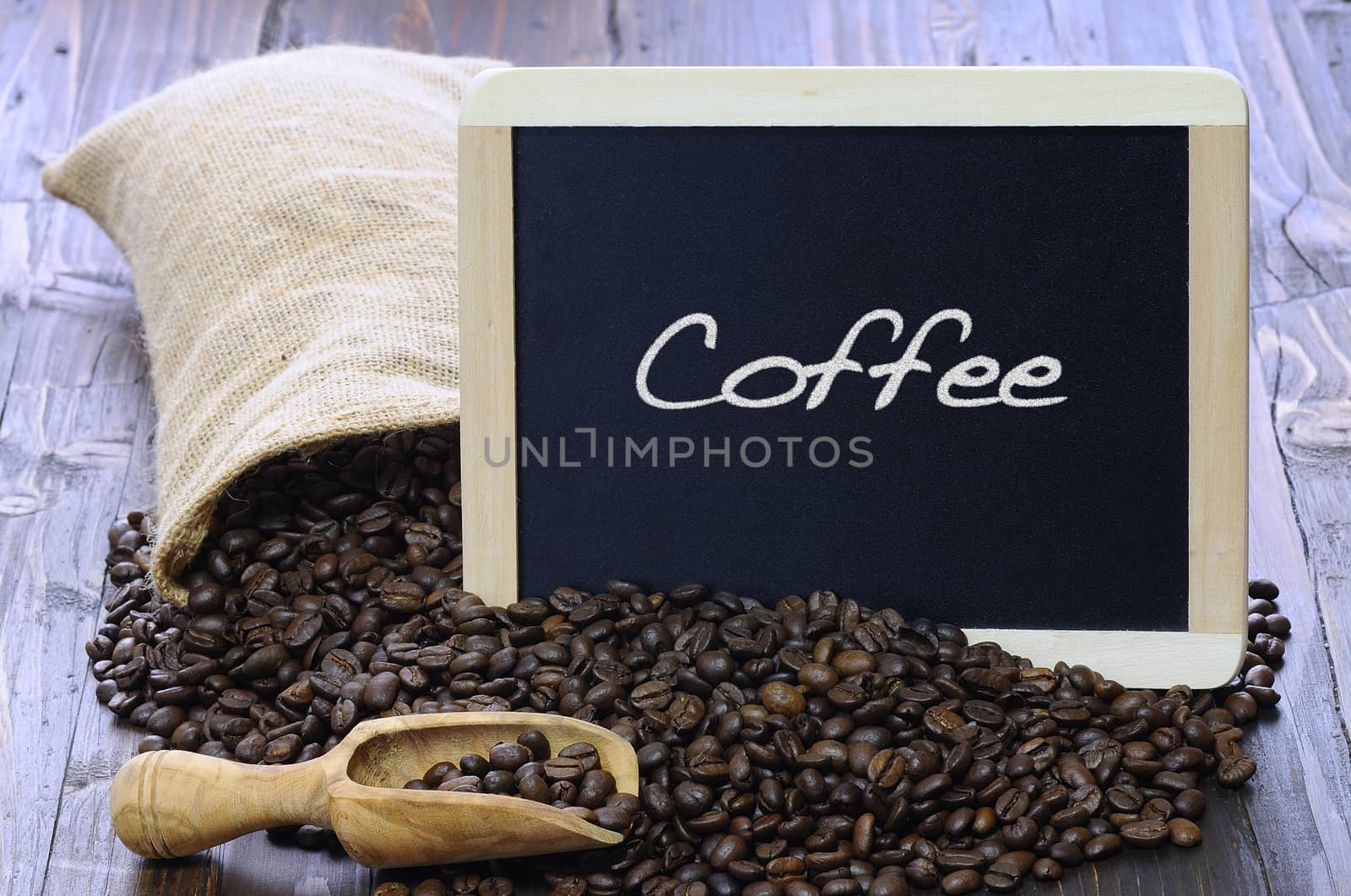 Coffee beans with blackboard on a wooden table.