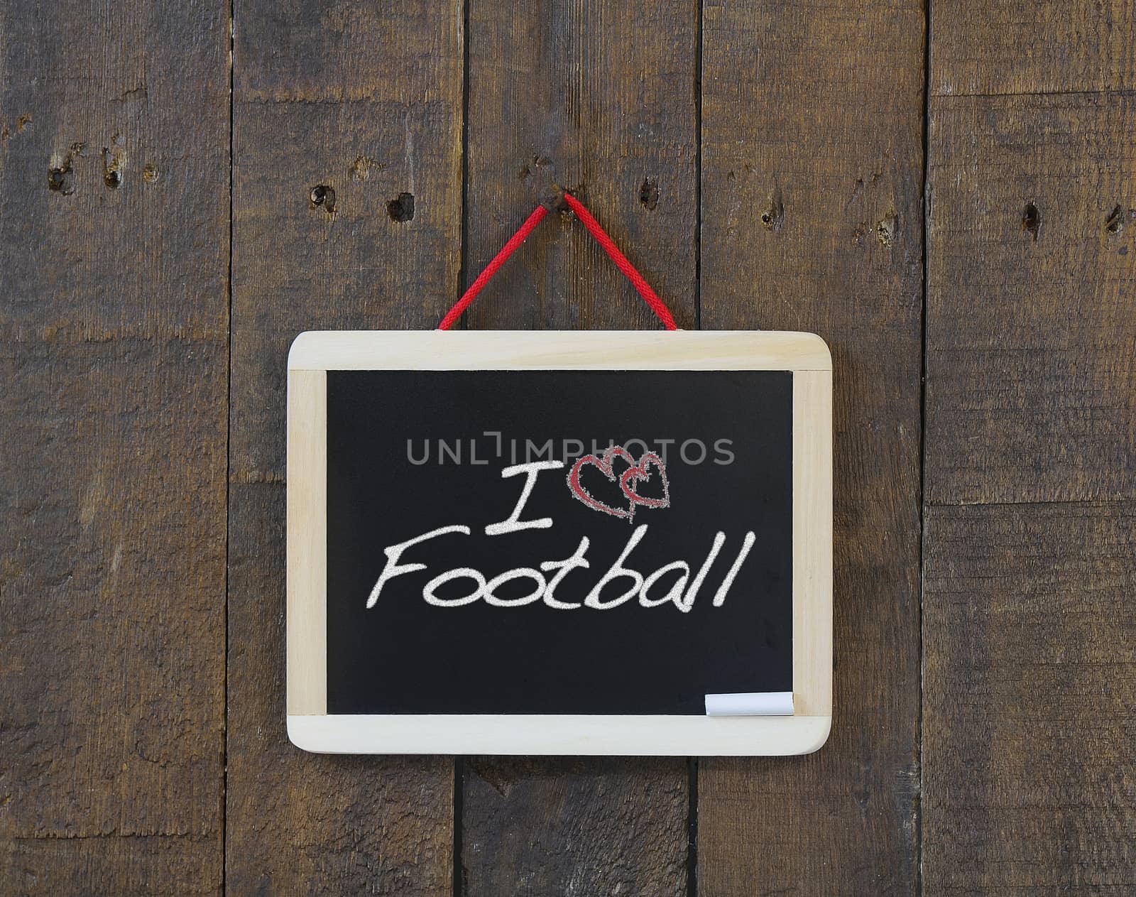 Blackboard hanging on a old wooden wall with word football.