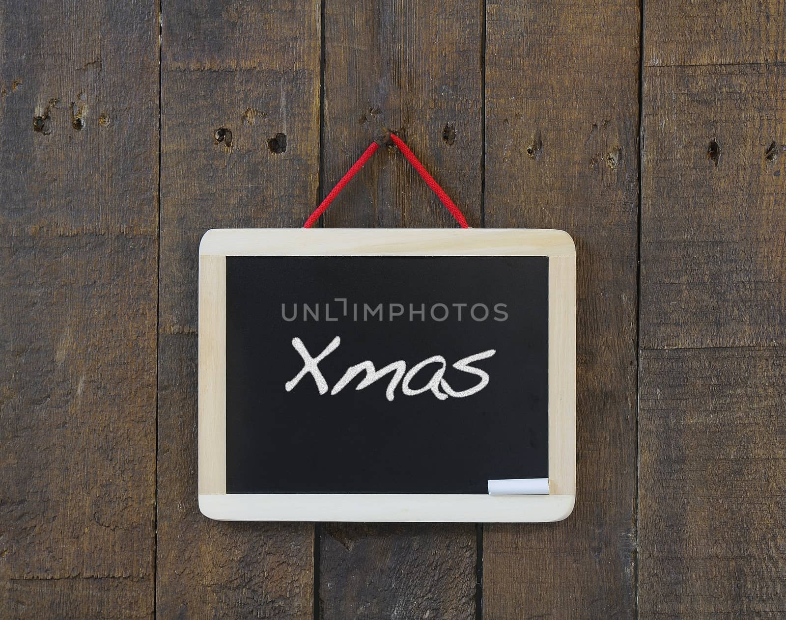 Blackboard hanging on a old wooden wall with Merry Christmas.