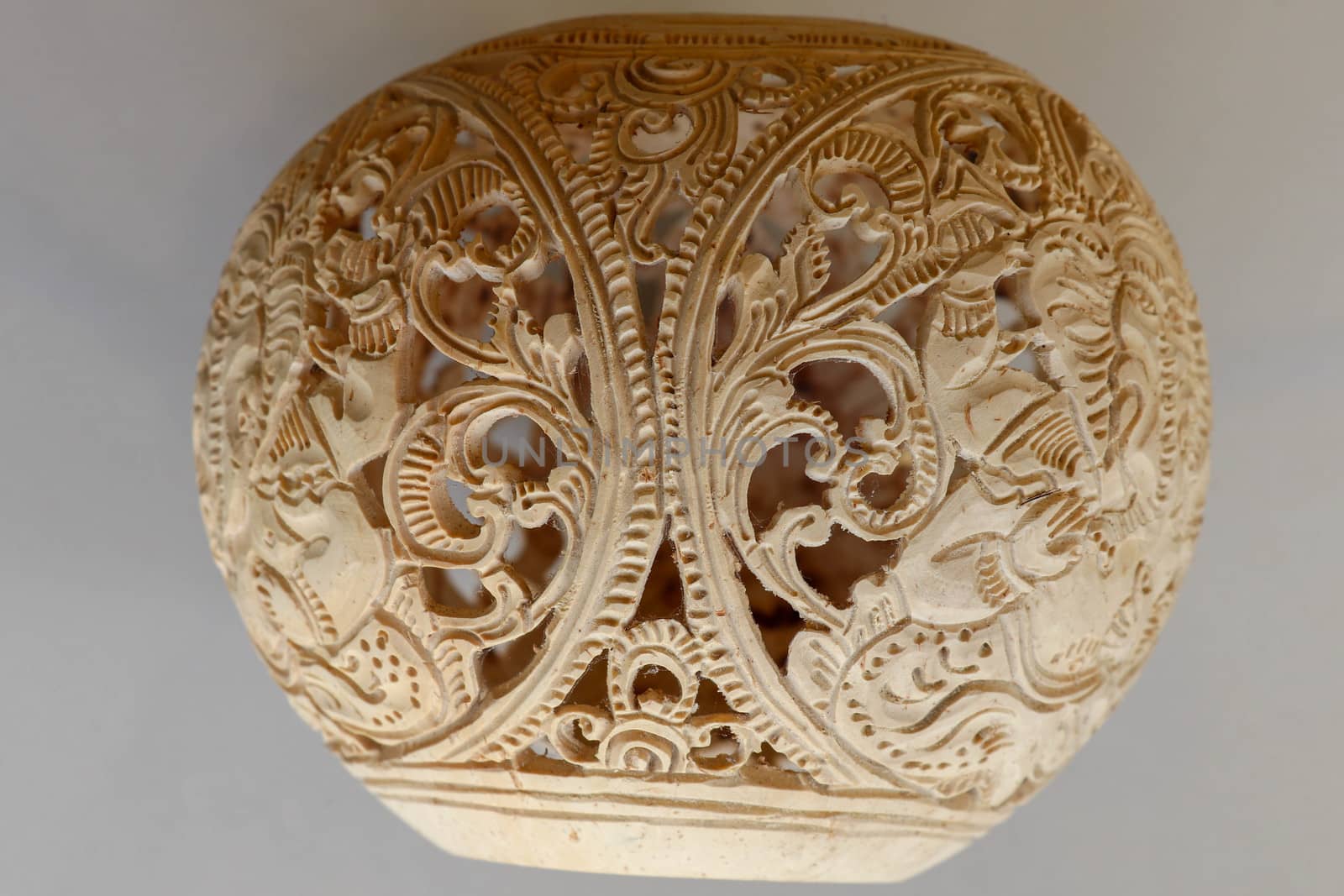 Close up of ornamental shell for candle. Hand carved decorative ornaments and motif of Hindu God Ganesha.Carved souvenir from white coconut. Traditional handicraft on Bali, Indonesia.