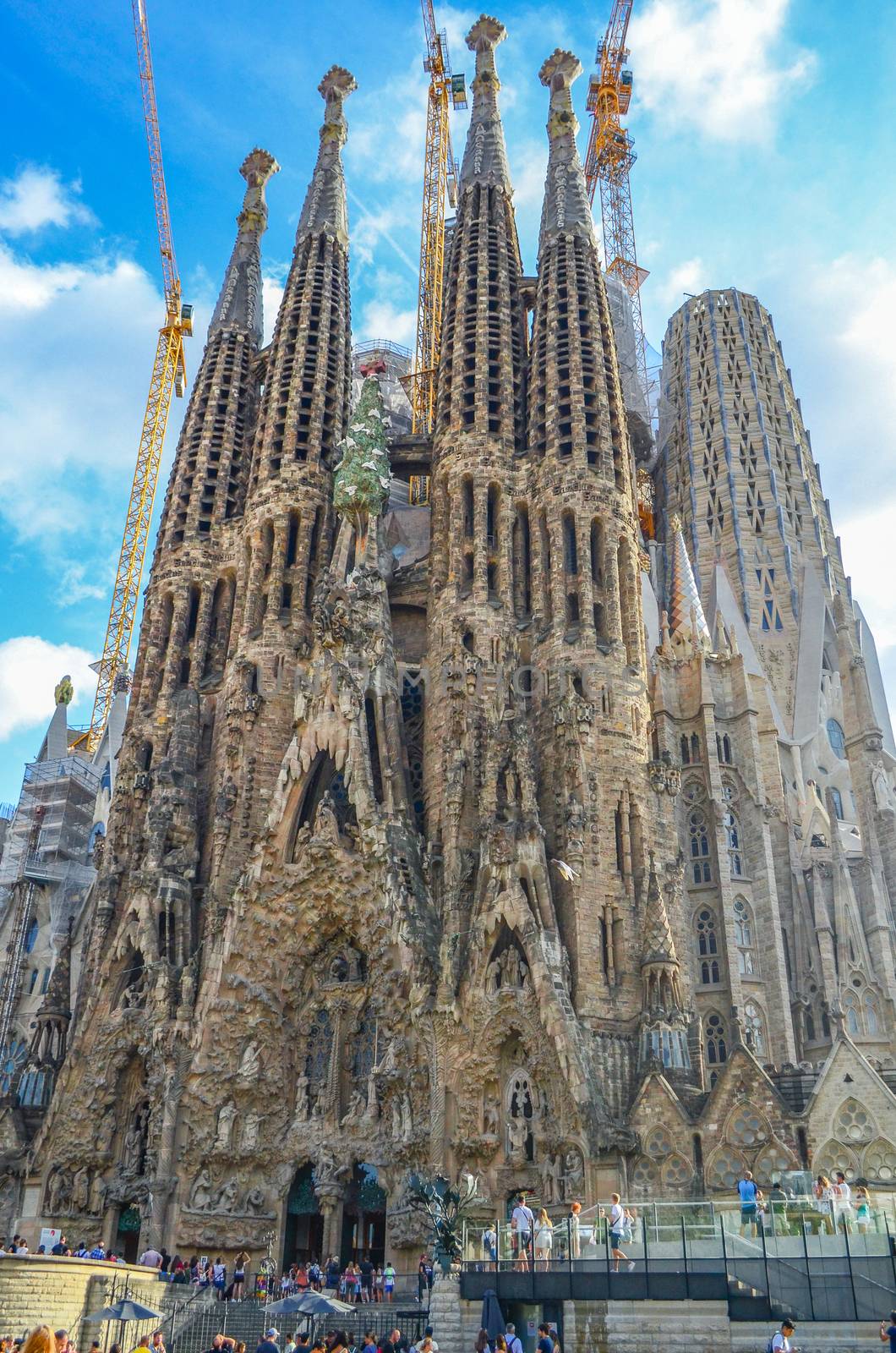 La Sagrada Familia with construction cranes on a blue sky fon in Barcelona, ​​Spain