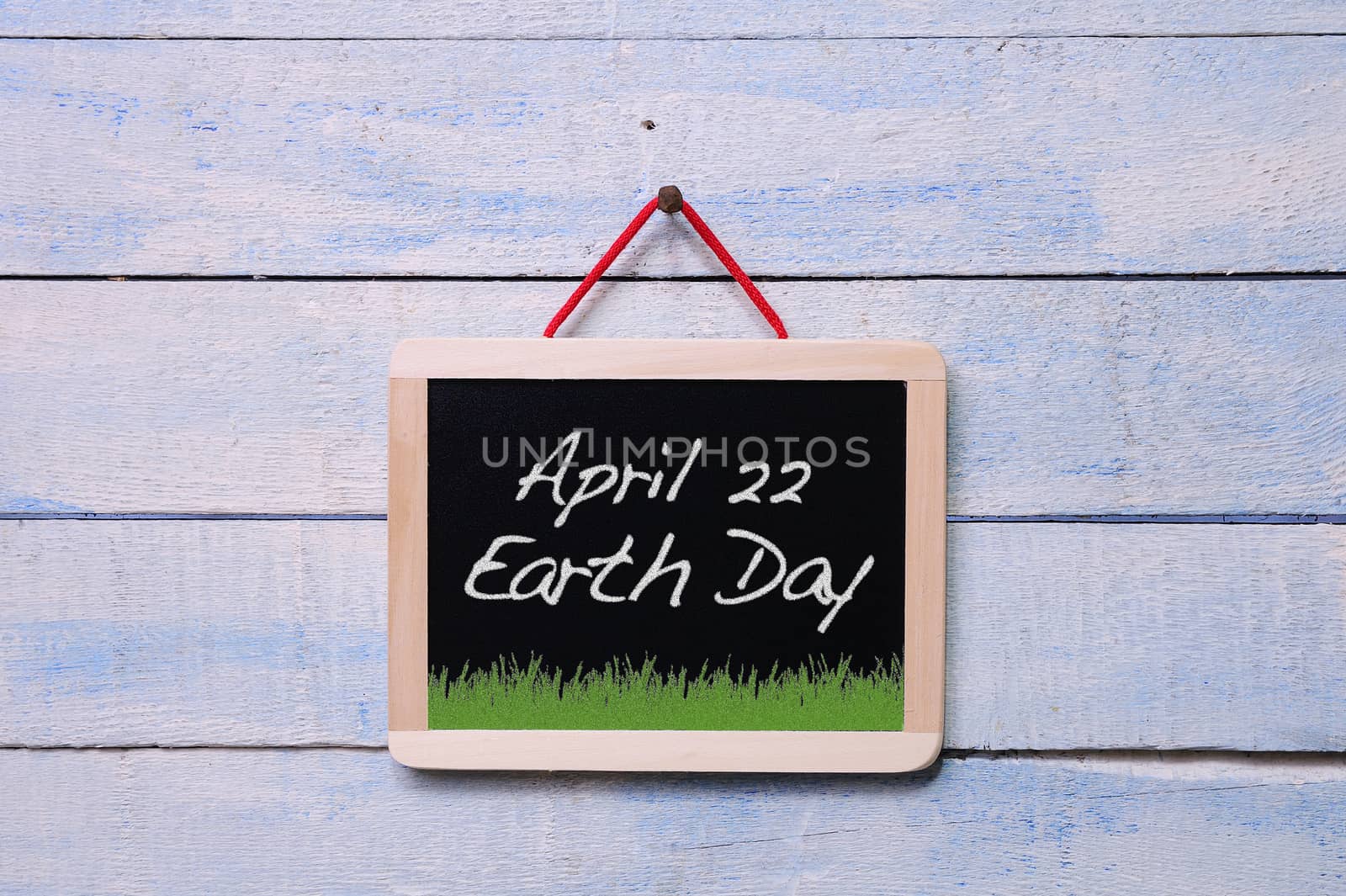 Blackboard hanging on a old wooden wall with Earth Day.