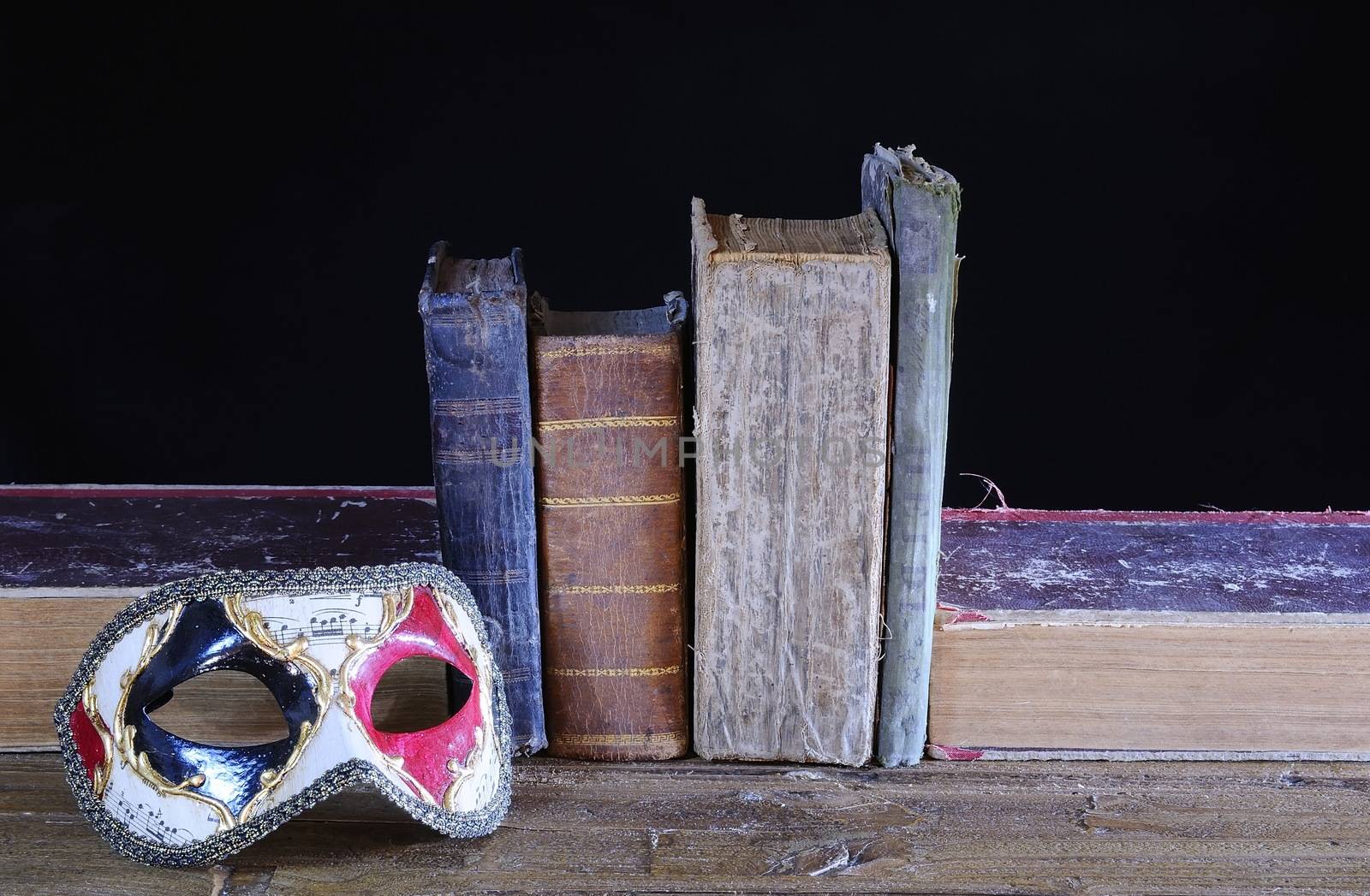 Carnival mask and old books in the table.