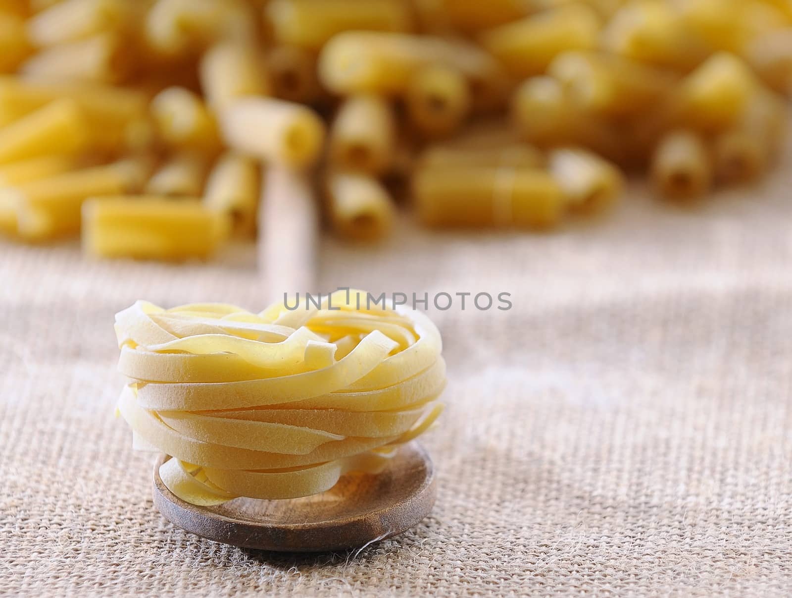 Tagliatelle in a spoon on the kitchen.