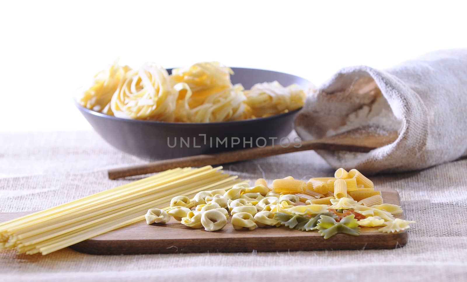 Pasta on a cutting board in a wooden table.