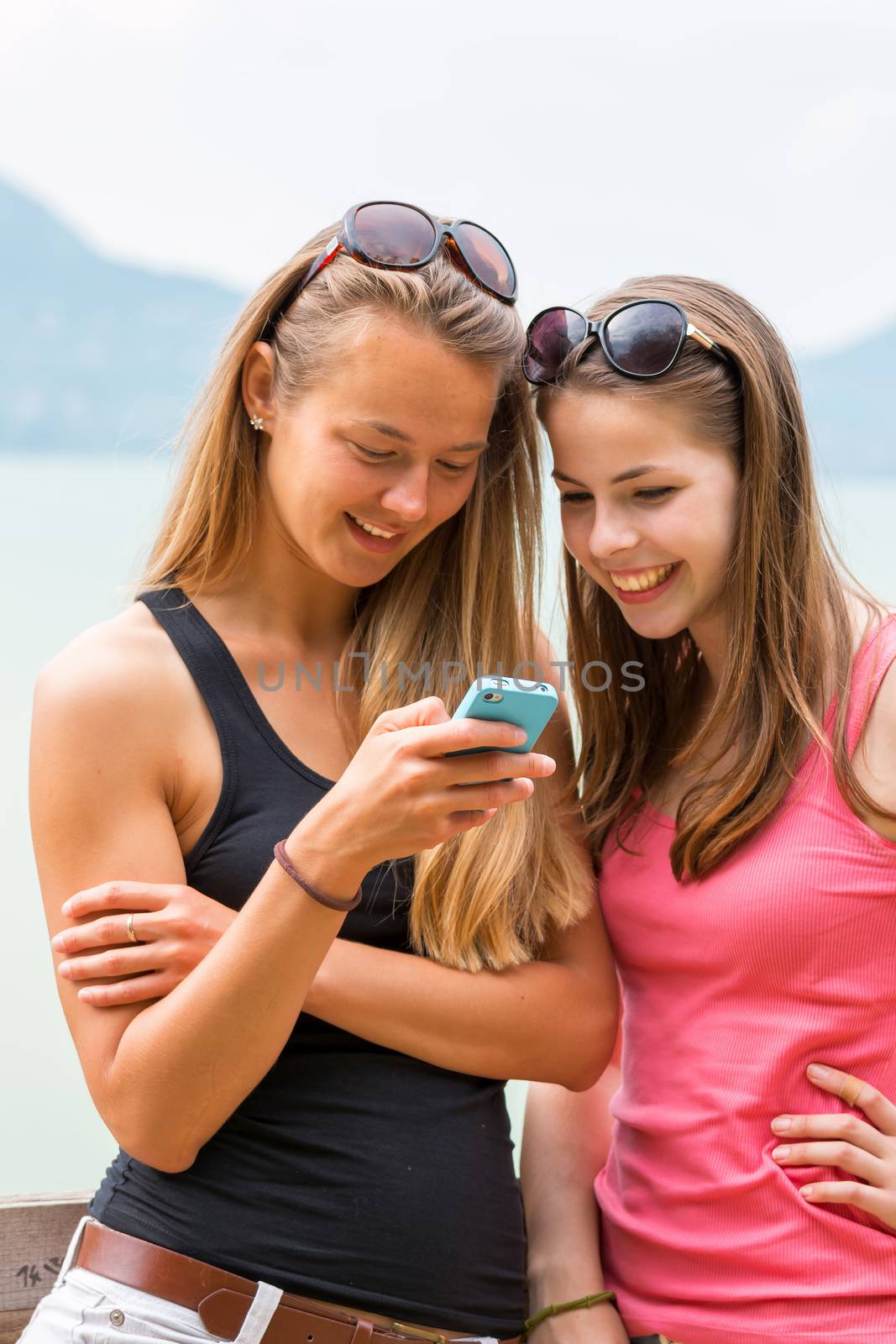 Two pretty young caucasian girls looking at mobile phone