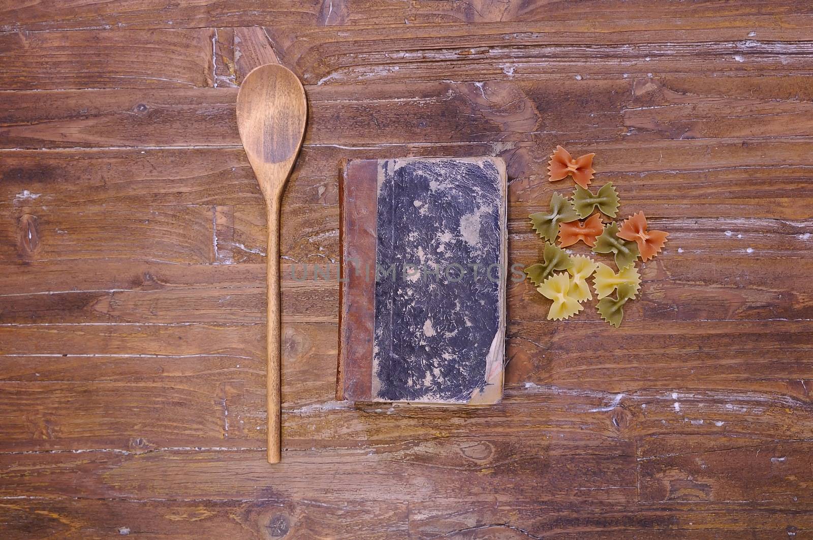 Cookbook over the kitchen table with pasta.
